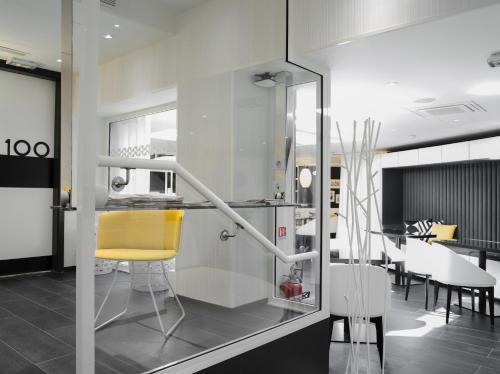 巴黎埃克塔香榭丽舍大街酒店的一间带黄色椅子的厨房和一间用餐室