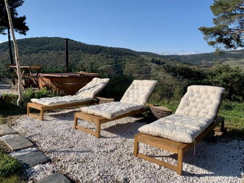 拉莫利纳Minds & Mountains Eco Lodge的坐在山顶的三把躺椅