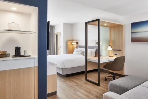 杰克逊维尔海滩SpringHill Suites by Marriott Jacksonville Beach Oceanfront的配有一张床和一张书桌的酒店客房
