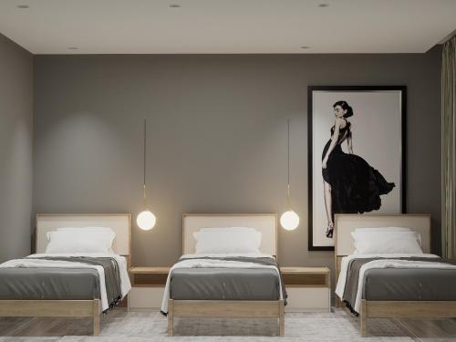 都拉斯Split Rooftop Suites的一间设有两张床的房间和一幅女人的画