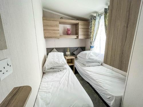 滨海克拉克顿Beautiful Caravan With Decking And Free Wifi At Highfield Grange Ref 26740wr的小型客房 - 带2张床和窗户