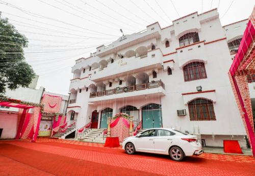 HasanganjJ C Guest House的停在大楼前的白色汽车