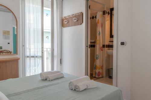 里米尼Hotel Greta B&B的卧室配有2条毛巾,位于床上