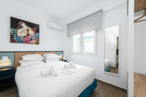 奥弗里安Danai & Palm Residential Complexes的白色卧室设有一张大床和镜子