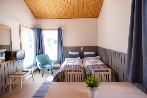 奥卢纳里卡瑞乡村度假屋假日公园的一间卧室配有两张床、一张桌子和一台电视。