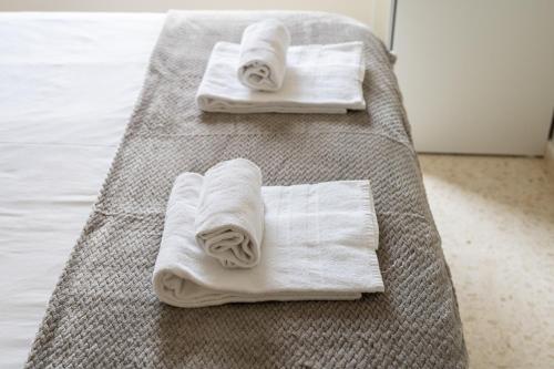 卡耐特蒂贝兰格Magnifico apartamento en Canet Playa by Hometels的床上的两条毛巾