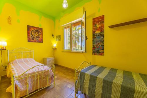 塔维亚诺Villetta Le Macchie的卧室拥有黄色的墙壁,设有一张床和窗户。