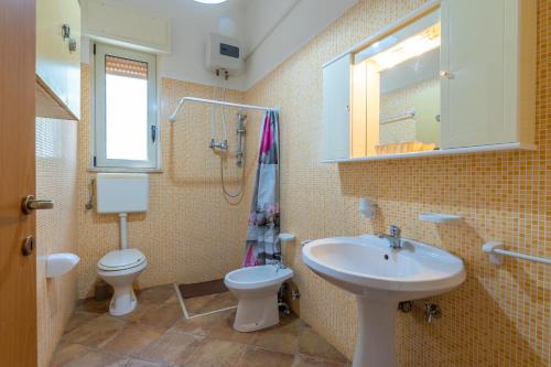 塔维亚诺Villetta Le Macchie的一间带水槽、卫生间和镜子的浴室