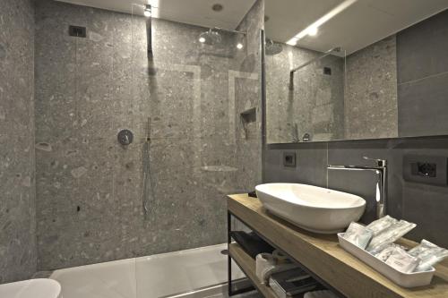 利索内莫泰阿斯科特酒店的一间带水槽和玻璃淋浴的浴室