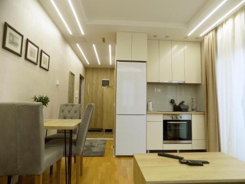 兹拉蒂博尔Anja的厨房配有白色橱柜和桌椅