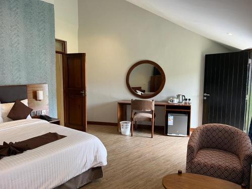 莫罗戈罗莫罗戈罗酒店 的一间卧室配有一张床、镜子和椅子