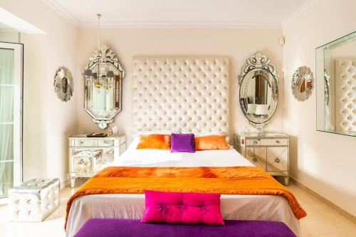 多列毛利诺斯Z&Olé的一间卧室配有一张大床,提供紫色和橙色枕头
