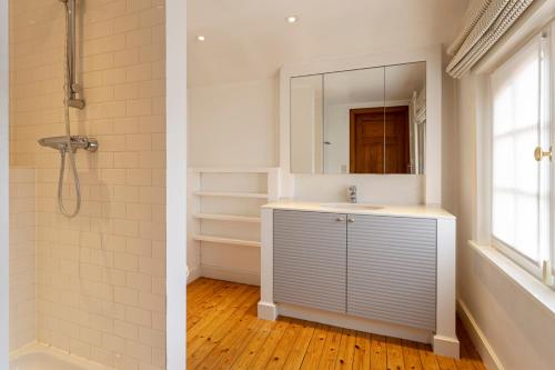 德帕内Villa Pauline的浴室配有盥洗盆和带镜子的淋浴