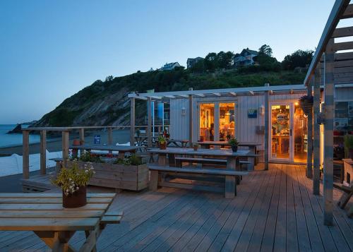 西卢港Millendreath Beach Resort的海滩上带野餐桌的甲板和房屋
