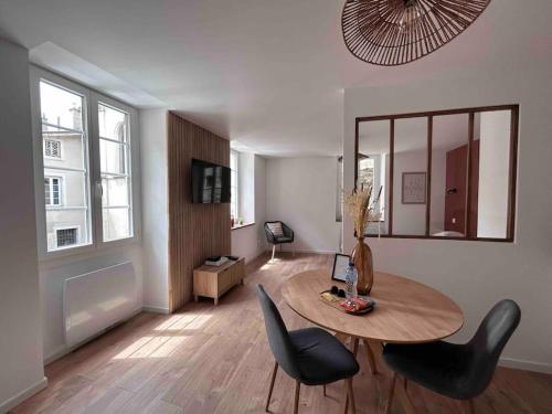 瓦朗斯Appartement au cœur de Valence的客厅配有桌椅和镜子