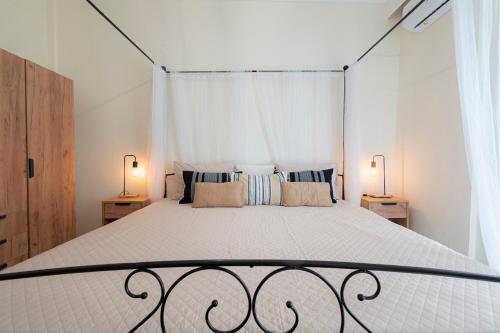ZográfosIrena House by RentalsPro - Dionisiou Halkidiki的一间卧室配有一张大床和两盏灯