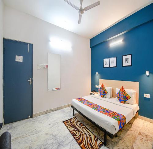 加尔各答FabHotel Silverkey Kalighat的一间卧室设有一张蓝色墙壁的大床