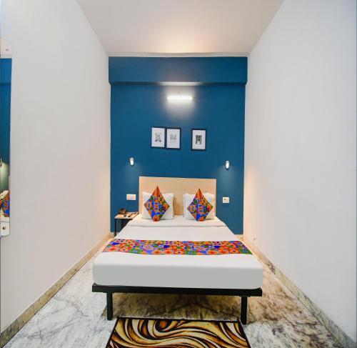 加尔各答FabHotel Silverkey Kalighat的一间卧室配有一张蓝色墙壁的床