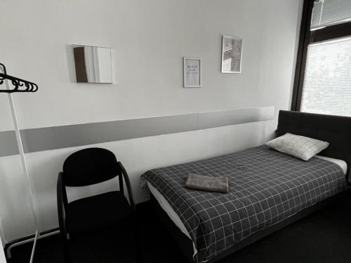 华沙Aleja "Solidarności"的一间小卧室,配有一张床和一把椅子