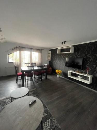 苏恰瓦Eroilor II Apartament的客厅配有桌椅和电视。