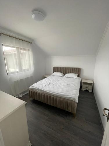 苏恰瓦Eroilor II Apartament的一间白色客房内的床铺卧室