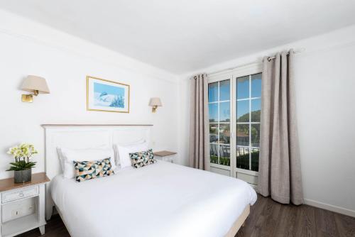 昂蒂布币奥酒店 - 昂蒂布海角的白色的卧室设有一张大床和一个窗户