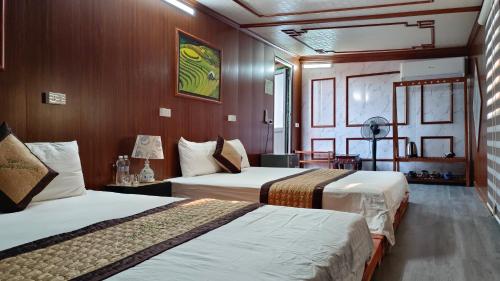 宁平Tam Coc Melody Homestay的酒店客房,设有两张床和木墙