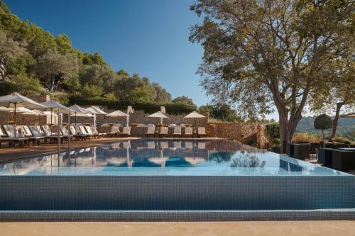 波连斯萨桑布鲁尔水疗酒店 的度假村的游泳池配有椅子和遮阳伞