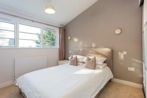 伯恩茅斯Family home close to Bournemouth town centre的卧室配有带枕头的大型白色床