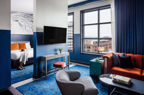 纳什维尔Dream Nashville, by Hyatt的酒店客房配有床、沙发和电视。