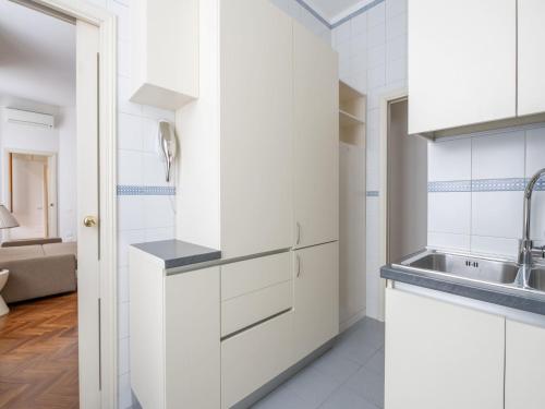 米兰The Best Rent - Gorgeous two-bedroom apartment in Porta Nuova district的厨房配有白色橱柜和水槽