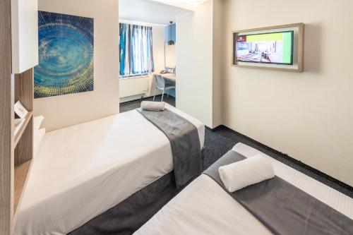 杰米斯顿Road Lodge Isando的一间酒店客房,设有两张床和电视