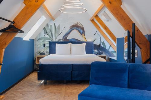 米德尔堡Hotel St Joris I Kloeg Collection的一间卧室配有一张床和一张蓝色的沙发