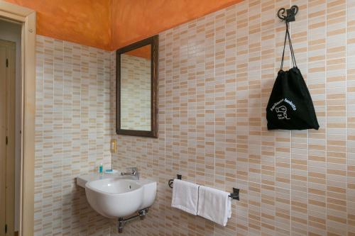 皮昂比诺Isolotto - Appartamento Quercia的浴室设有水槽,墙上装有黑袋
