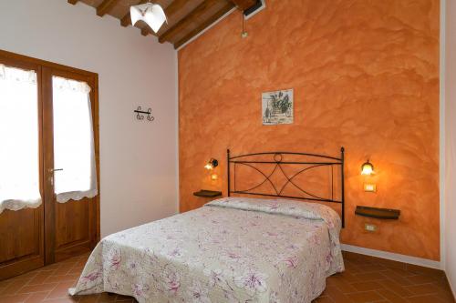 皮昂比诺Isolotto - Appartamento Quercia的一间卧室设有一张床和橙色的墙壁