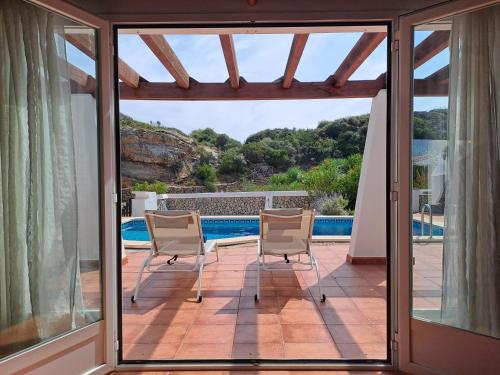 福尔内利斯Villa Xalina - Piscina / bbq / jardín的一个带两把椅子的庭院和一个游泳池