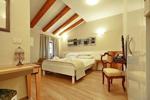 布泽特维拉吾拉塔精品酒店的一间卧室配有一张床、一张桌子和一把椅子