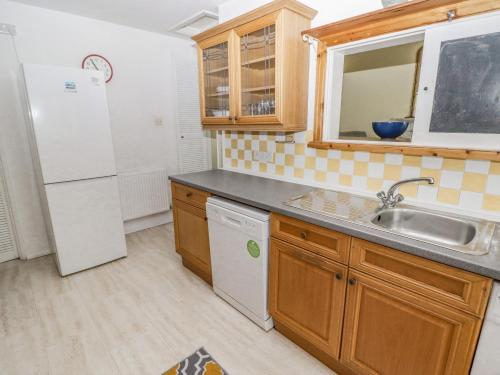 滕比Little Rosemount的厨房配有水槽和冰箱