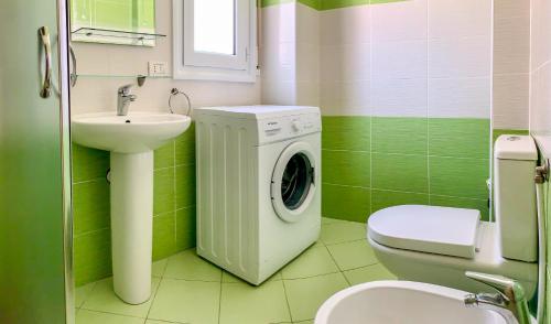 奥里库姆Endy Apartaments的绿色浴室设有洗衣机和水槽