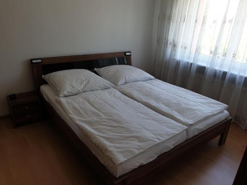 安贝格Ferienwohnung Nella的一张带白色床单和枕头的床,靠窗