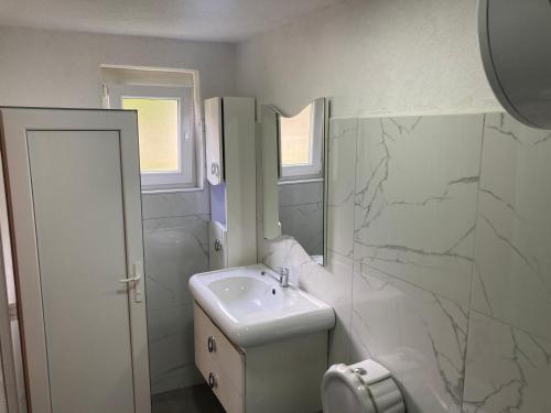 瓦勒博内Bujtina Arturi的白色的浴室设有水槽和镜子
