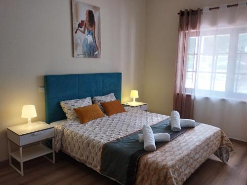 Salir de PortoCASA DA DUNA - Salir do Porto的一间卧室配有一张带蓝色床头板的床和窗户