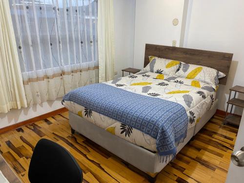 库斯科Hogarcito的卧室配有床、椅子和窗户。