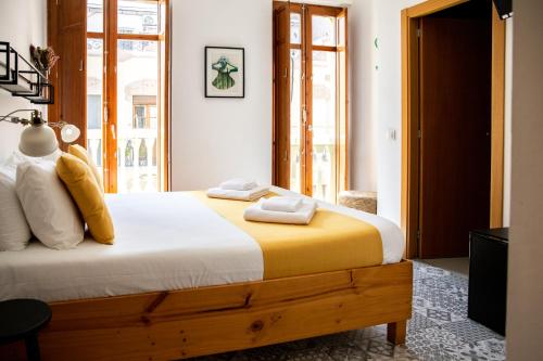 瓦伦西亚扎拉莫拉住宿加早餐旅馆的一间卧室配有一张带黄色和白色枕头的大床