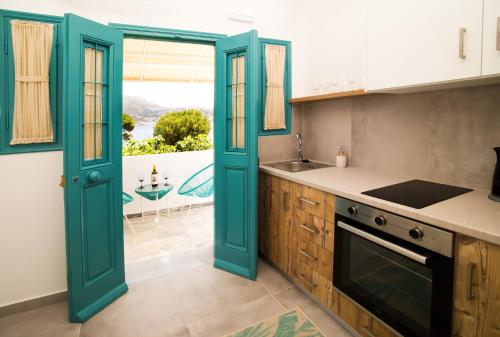 TelendosSUITES DREAM TELENDOS的厨房设有蓝色的门、水槽和炉灶。