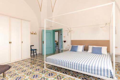 切萨雷奥港Antica Villa del Conte的一间白色卧室,配有一张床和一个蓝色的门