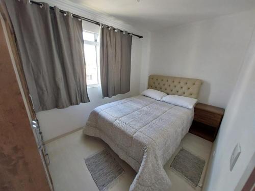 乌尼昂-达维多利亚Apartamento inteiro com garagem coberta的一间小卧室,配有床和窗户