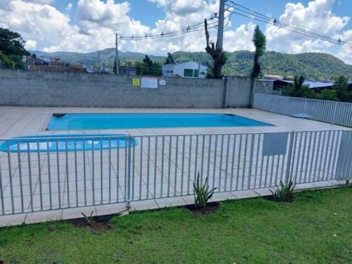 乌尼昂-达维多利亚Apartamento inteiro com garagem coberta的院子内带两个游泳池的白色围栏