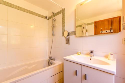 CellesLe Mas de Riri的一间带水槽、浴缸和镜子的浴室