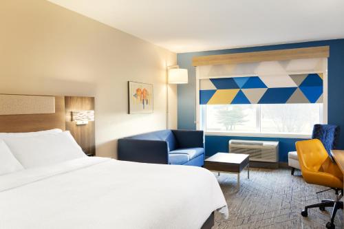 南黑文Holiday Inn Express - South Haven, an IHG Hotel的酒店的客房 - 带一张床、椅子和窗户